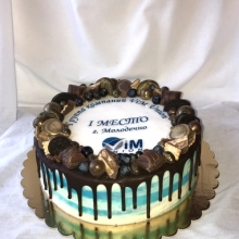 Корпоративный торт декорированный логотипом компании и шоколадными подтёками с конфетами.