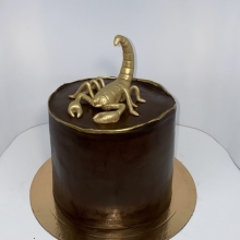 Стильный праздничный торт декорированный золотой фигуркой скорпиона заказать в Минске недорого.