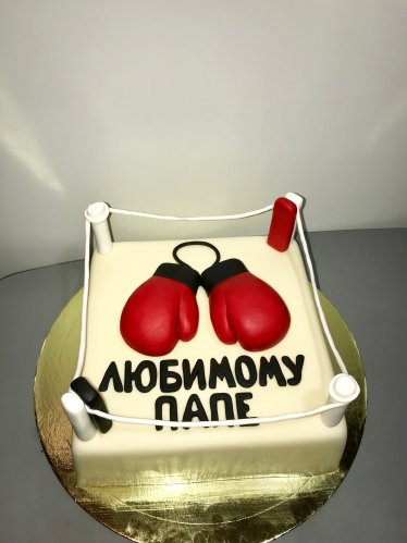 Торт выполненный в форме в боксерского ринга с красными перчатками.
