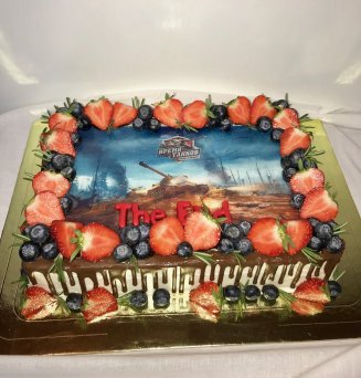 Прямоугольный торт с фотопечатью логотипа, украшен ягодами и полит шоколадом.