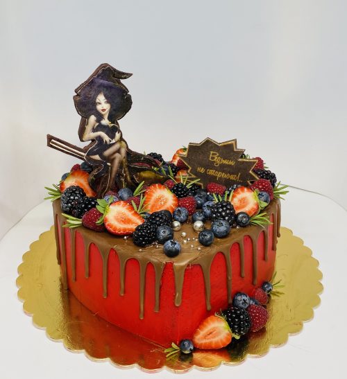 Торт выполненный в форме сердца,декорированный свежими ягодами клубники и голубики.