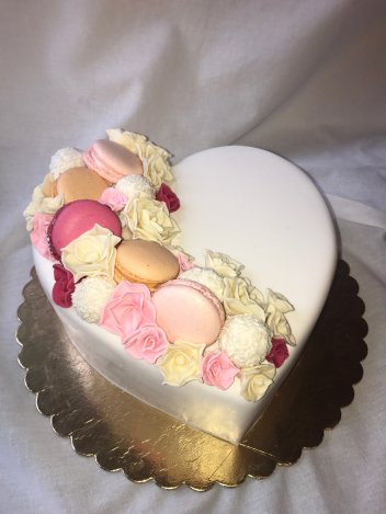 Торт выполненный в форме сердца,декорированный,печеньем марарони и нежными розочками.